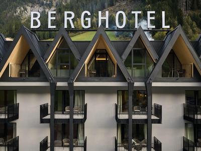 Blick auf ein Berghotel mit auffälliger Spitzdacharchitektur und großen Fenstern.