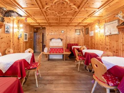Wood-paneled dining room with set tables and traditional decorations.