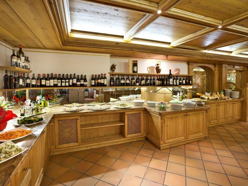 Ein Buffet mit verschiedenen Speisen und Getränken in einem warmen, holzverkleideten Raum.