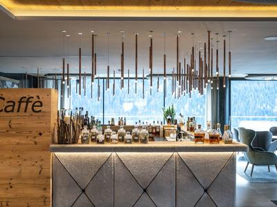 Moderner Hotel-Cafébereich mit beleuchtetem Tresen und hängenden Lampen