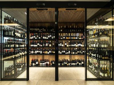 Moderner Weinkeller mit Glaswänden und einer Vielzahl von Weinflaschen in einem Hotel.