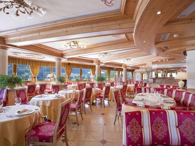 Großes, elegantes Restaurant mit roten Sesseln, runden Tischen und großen Fenstern mit Ausblick.