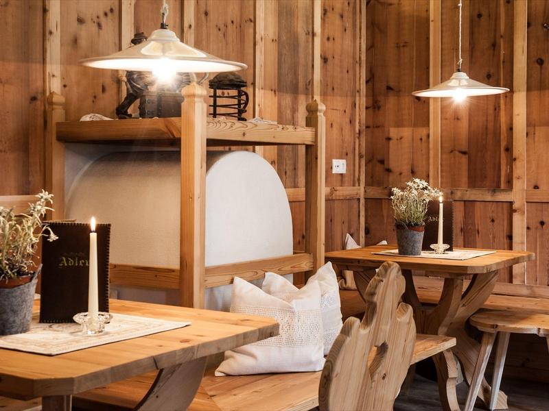 Gemütliches Holzrestaurant mit rustikalen Tischen, Stühlen und gedämpftem Licht.