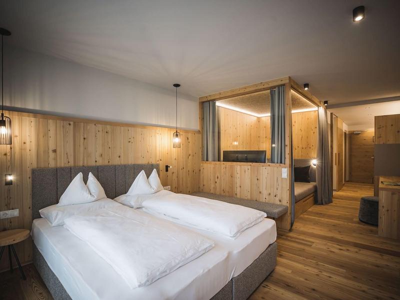 Helles Holz-Schlafzimmer mit zwei Einzelbetten, modernen Lampen und minimalistischem, gemütlichem Design.