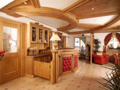 Helle Holzlamellen-Küche mit roten Akzenten und offener Verbindung zum Wohnzimmer mit roten Möbeln.