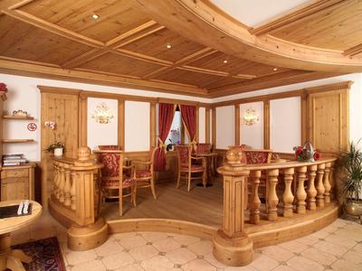 Eleganter Hotel-Loungebereich mit Holzvertäfelung, gepolsterten Sesseln und Tischen.