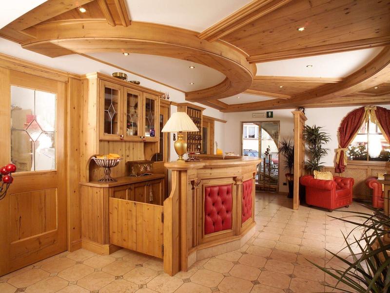 Helle Holzlamellen-Küche mit roten Akzenten und offener Verbindung zum Wohnzimmer mit roten Möbeln.