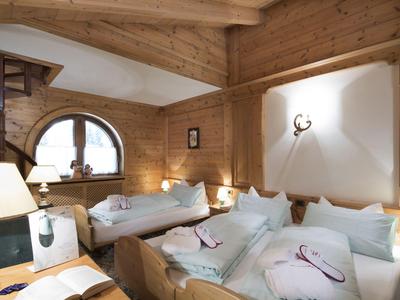 Gemütliches Holzzimmer mit Betten und weicher Beleuchtung in einer Lodge.