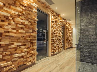 Moderner Hotelflur mit Wänden aus Holzblöcken und Holzboden.