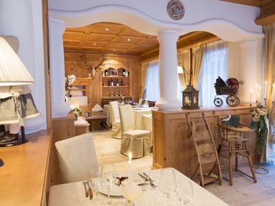 Helles Restaurant mit Holzmöbeln, gedeckten Tischen und gemütlicher Atmosphäre.