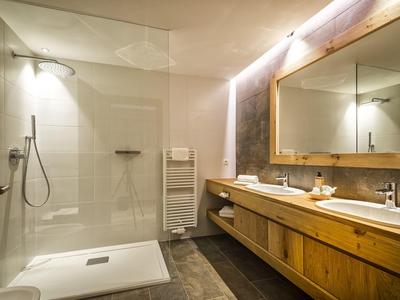 Modernes Badezimmer mit Glaskabine, Holzwaschbeckenunterschrank und großem Spiegelwand.