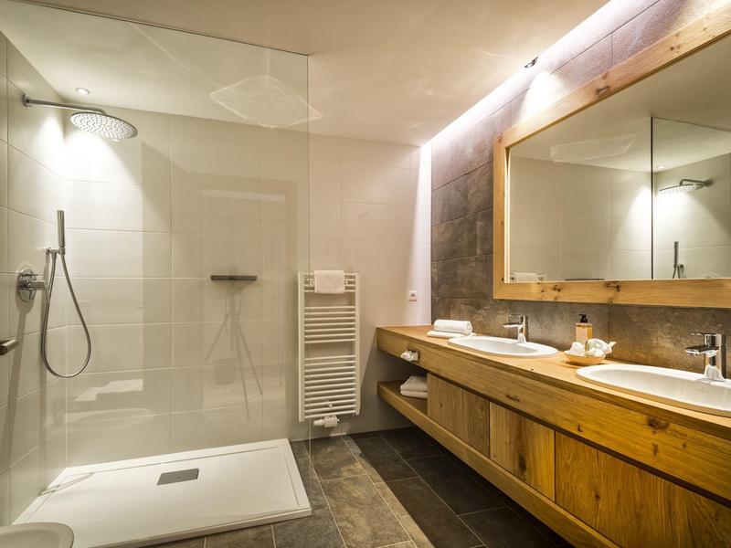 Modernes Badezimmer mit Glaskabine, Holzwaschbeckenunterschrank und großem Spiegelwand.