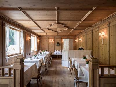 Ristorante rustico con pareti in legno, tovaglie bianche e luce naturale.