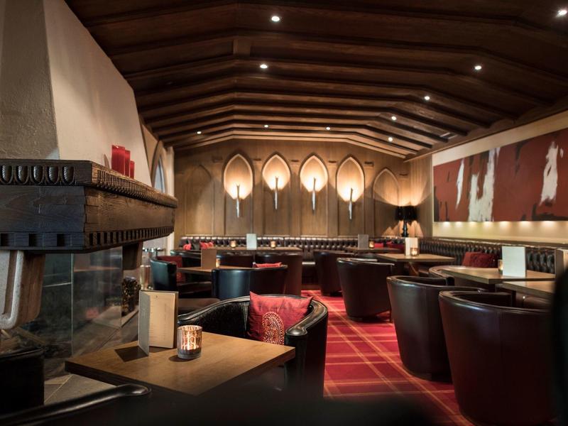 Accogliente lounge dell'hotel con camino, poltrone in pelle e interno in legno caldo.