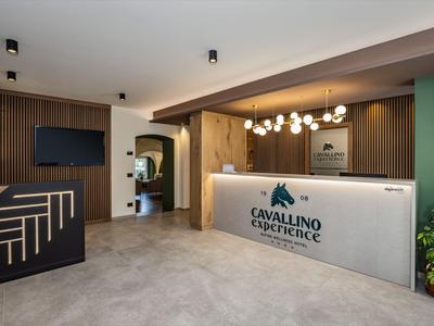 Moderner Hotel-Lobbybereich mit Empfangstresen, Holzverkleidung und stilvoller Beleuchtung.