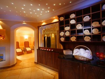 Espace spa confortable avec chaises longues relaxantes, lumière chaude et serviettes.