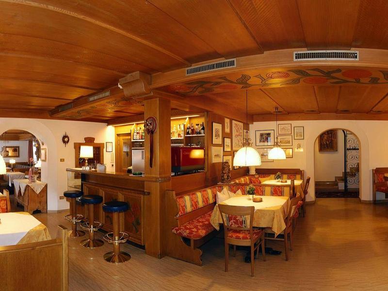 Salle à manger d'hôtel confortable avec mobilier en bois et éclairage chaleureux.