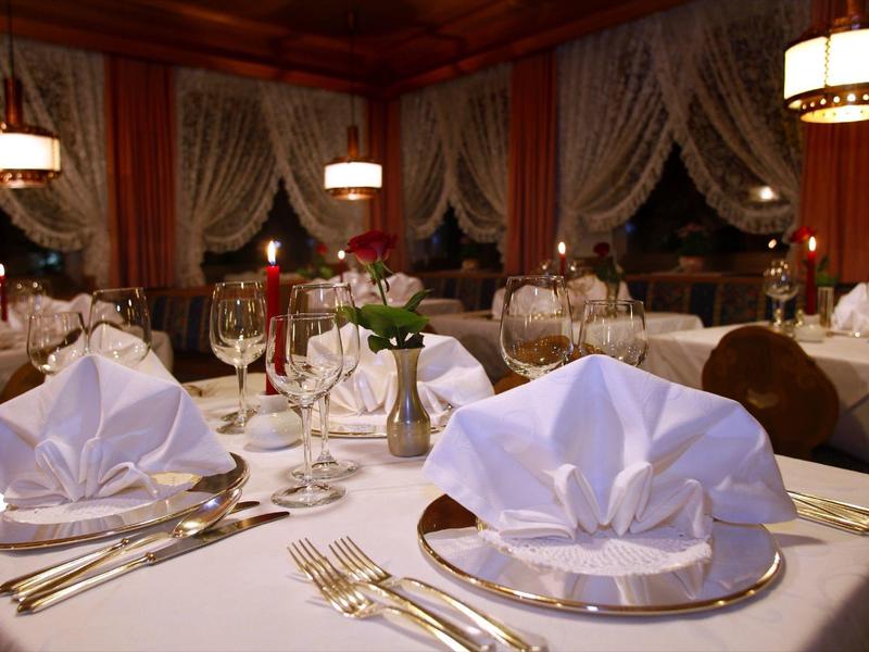 Restaurant élégant avec des tables dressées en blanc et des serviettes délicatement pliées.