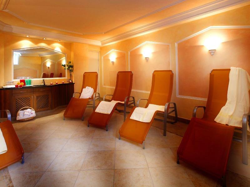 Salle de relaxation avec chaises longues et murs orange chaleureux à l'hôtel.