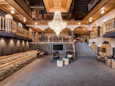 Luxusní hotelové foyer s elegantním lustr, schodištěm a pohodlnými posezeními