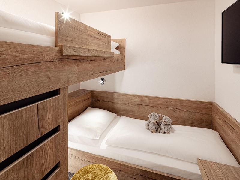 Malý pokoj s palandou a dřevěným obkladem, útulný a moderní design.