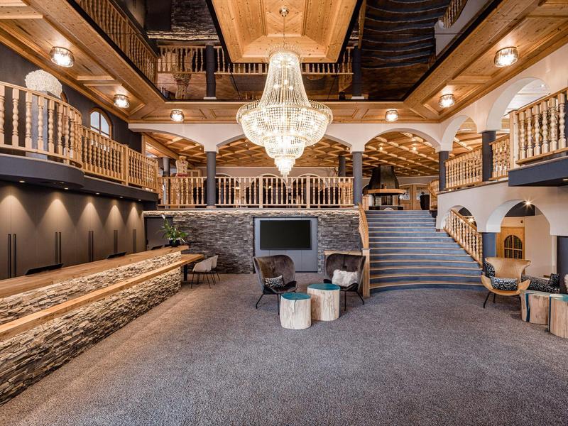 Luxusní hotelové foyer s elegantním lustr, schodištěm a pohodlnými posezeními