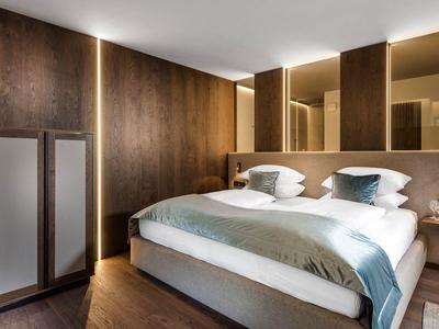 Gezellige hotelkamer met houten muren, een tweepersoonsbed en zachte sfeerverlichting.