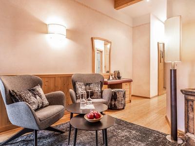 Gezellige hotel zithoek met twee fauteuils, een ronde tafel en warme verlichting.