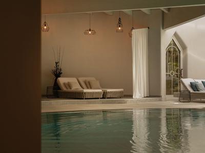 Piscina d'hotel moderna con lettini e luce calda in un ambiente tranquillo.