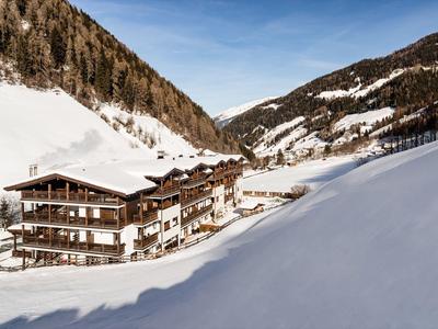 Hotel in besneeuwd berglandschap onder een heldere blauwe lucht