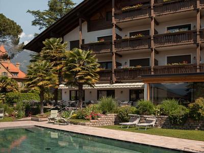 Hotel met houten balkons en een buitenzwembad in een rustige tuinomgeving.