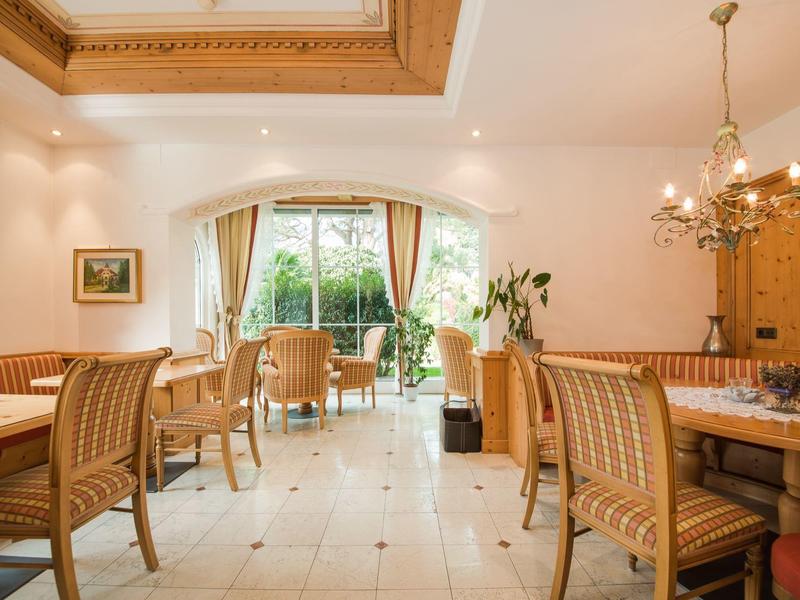 Lichte eetkamer met houten meubels en uitzicht op tuin door grote ramen.