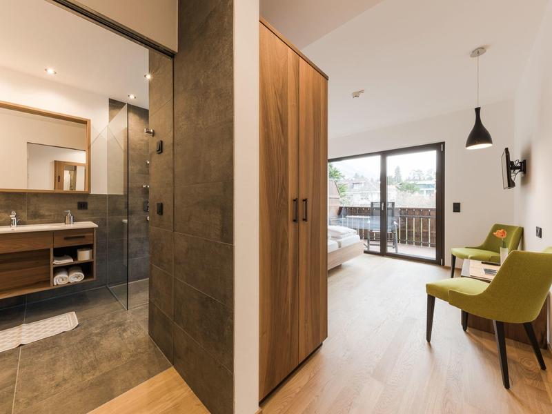 Moderne hotelgang met uitzicht op de badkamer en een slaapkamer met balkon.