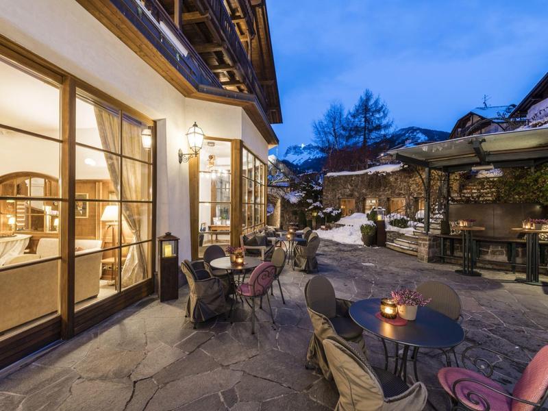 Cozy hotel terrace with chairs and tables at dusk.