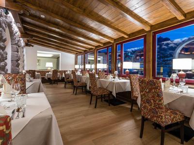 Ristorante elegante con soffitto a travi di legno e vista sul cielo serale.