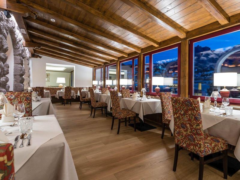 Ristorante elegante con soffitto a travi di legno e vista sul cielo serale.