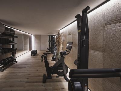 Modern gym with equipment in a warmly lit hotel area.