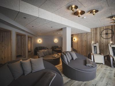Gemütliches Wohnzimmer mit grauen Sofas, Holzwänden und warmem Deckenlicht in modernem Stil.