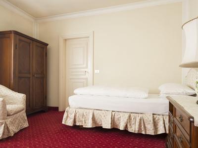 Einfach eingerichtetes Zimmer mit rotem Teppich, Holzmöbeln und weißen Polstermöbeln.