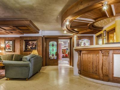 Gemütliche Wohnzimmer mit holzverkleidetem Tresen, Sofas, Teppich und warmem Licht.