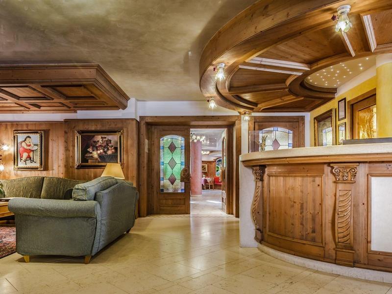 Gemütliche Wohnzimmer mit holzverkleidetem Tresen, Sofas, Teppich und warmem Licht.