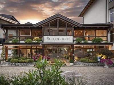 Edificio dell'hotel moderno con grandi vetrate e rivestimento in legno al tramonto.