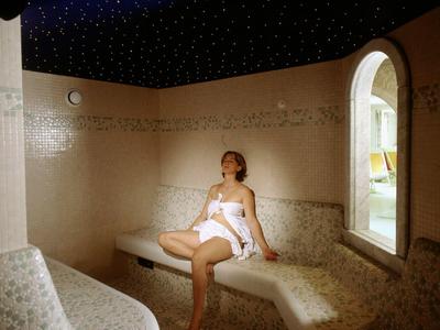 Femme se détend dans un hammam avec un plafond étoilé.