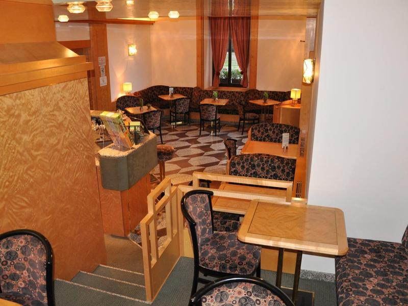 Coin salon confortable avec mobilier en bois et fauteuils rembourrés dans un restaurant d'hôtel.