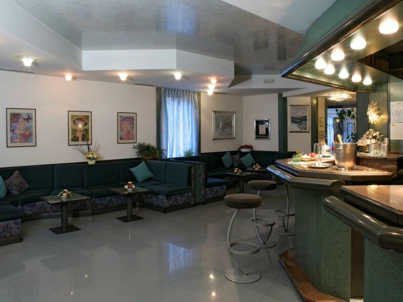 Espace salon d'hôtel confortable avec sièges et bar à l'arrière-plan