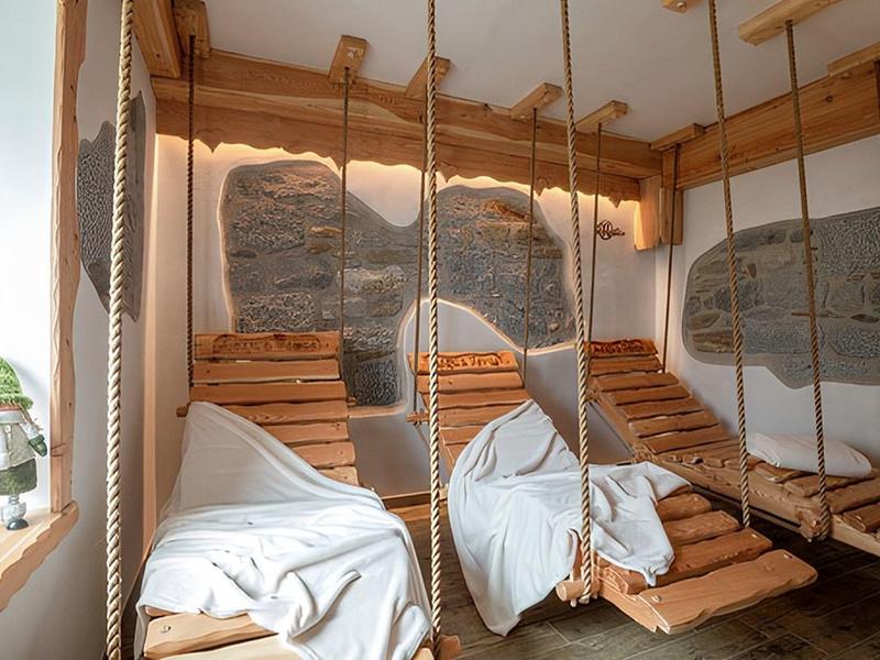 Gezellige schommelstoelen met witte dekens in een lichte, natuurlijke kamer.