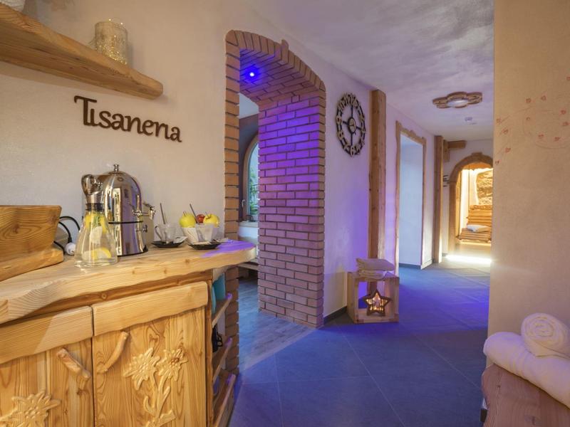 Gezellige hotelgang met houten meubels, theehoek en zachte verlichting.