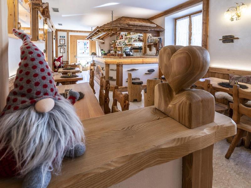 Restaurant d'hôtel chaleureux avec mobilier en bois rustique et nain décoratif sur la rampe.