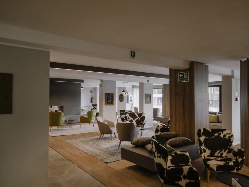 Moderní lounge s posezením a velkými okny v hotelu