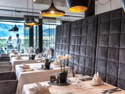 Elegant restaurant met gedekte tafels en groot raam met uitzicht.